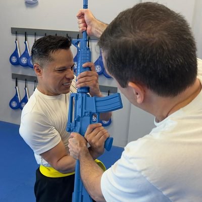 Students training with simulated weapon defense tools at Real Krav Maga Academy.