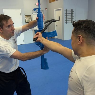 Students practicing a tomahawk defense technique at Real Krav Maga Academy.